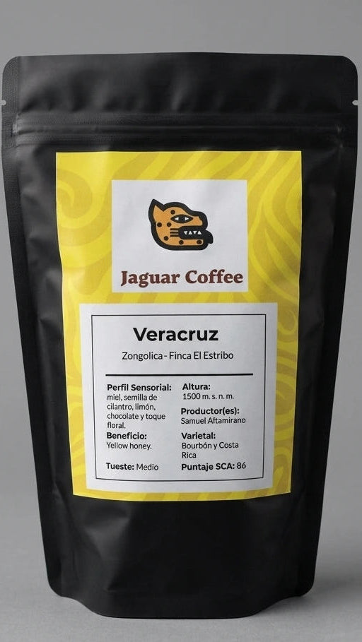 La iluminación de estudio, difusa y uniforme, resalta el diseño limpio de la etiqueta amarilla y blanca de Jaguar Coffee. En ella se leen claramente los detalles técnicos del lote de Samuel Altamirano: 1500 m.s.n.m., proceso Yellow Honey, varietales Bourbón y Costa Rica, y un puntaje SCA de 86, proyectando una imagen de elegancia salvaje y calidad experta.